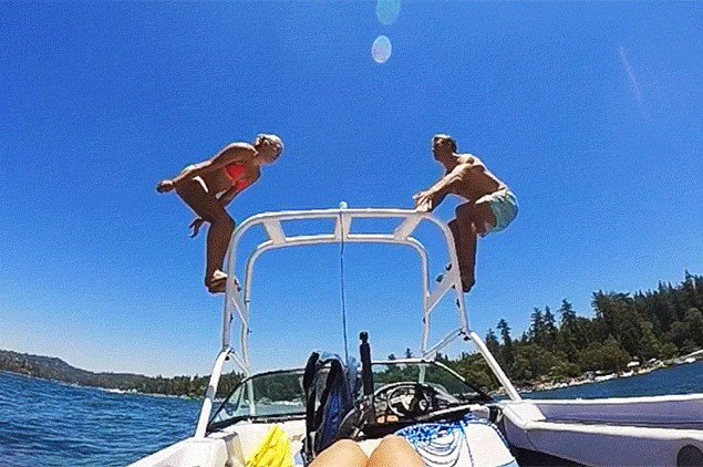 Two guest diving out of a boat, doing a back-flip into Lake Arrowhead.