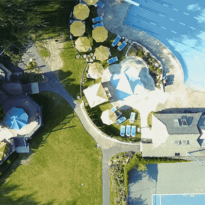 A drone looking down at the outdoor of the pool area as it ascends.